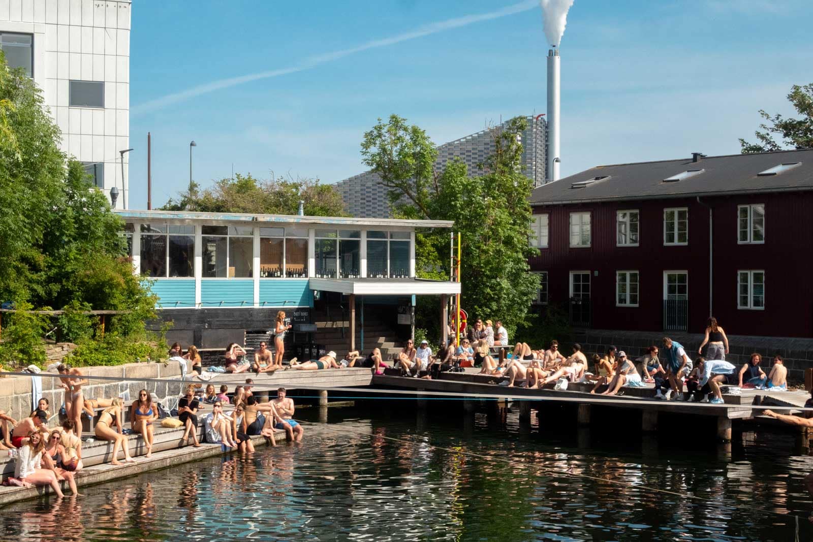 People seated on dock at waterfront.