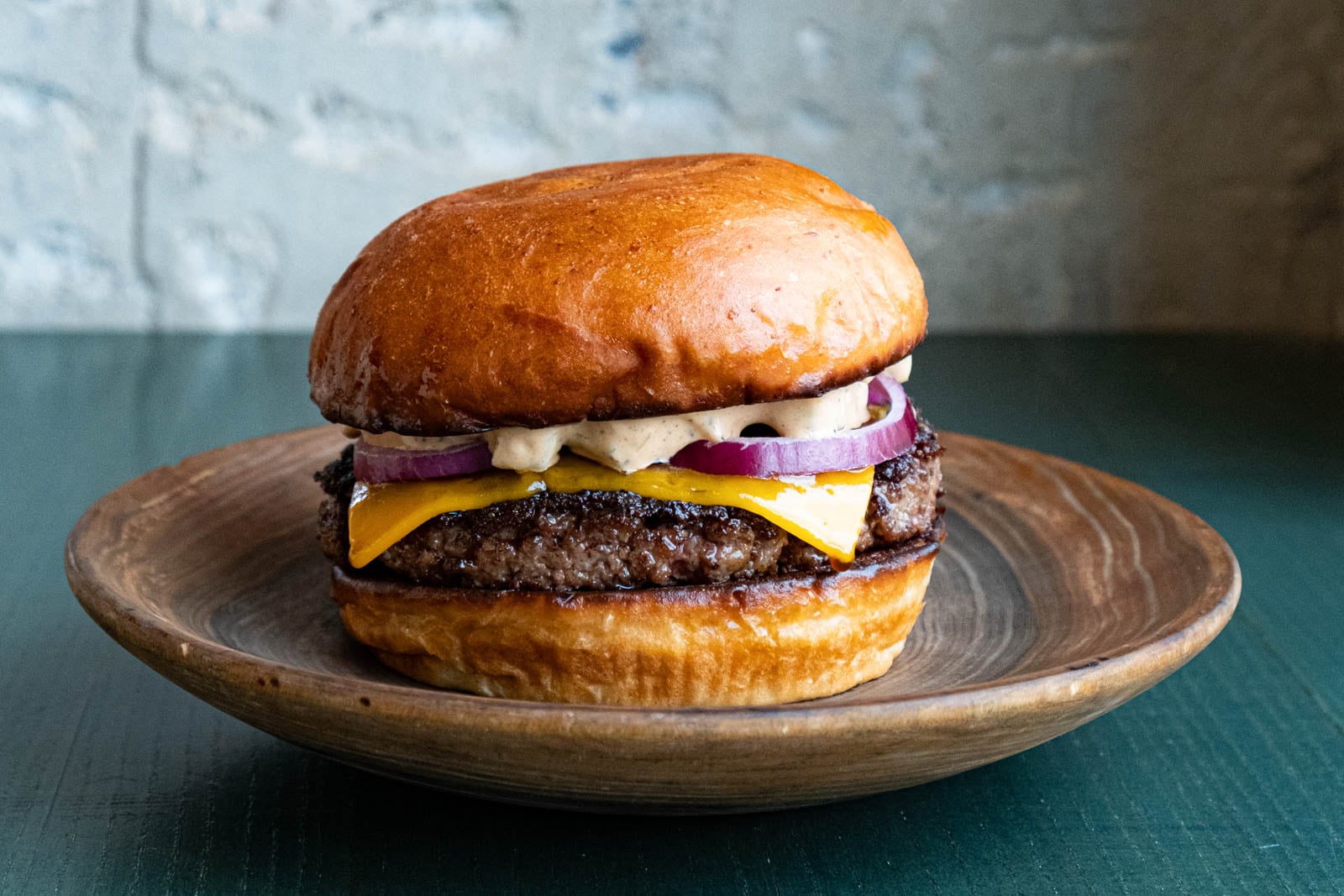 Burger on wooden plate.